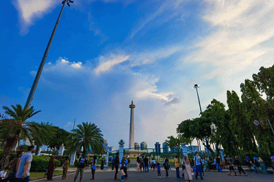 Warga berfoto di halaman luar Monumen Nasional (Monas) Jakarta, Kamis (5/5/2022).
