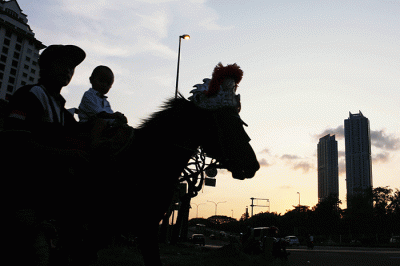 Mengisi waktu akhir libur lebaran warga membawa anaknya untuk wisata menunggang kuda di kawasan Kemayoran, Jakarta, Minggu (8/5/2022).