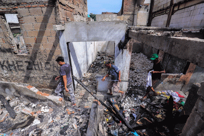 Warga beraktivitas ditengah pemukiman yang bekas terbakar di kawasan Pasar Gembrong, Jakarta Timur, Selasa (10/5/2022).