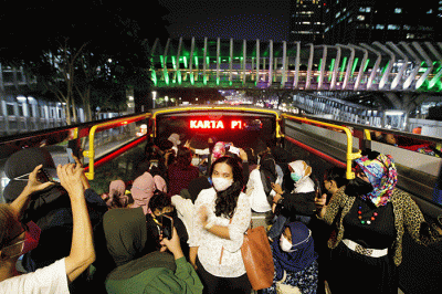 Warga menikmati keindahan kota Jakarta pada malam hari dari atas bus wisata Transjakarta di kawasan Jakarta, Rabu (11/5/2022).