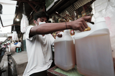 Pedagang menunjukkan minyak goreng curah di Pasar Kecapi, Kota Bekasi, Jawa Barat, Kamis (12/5/2022).