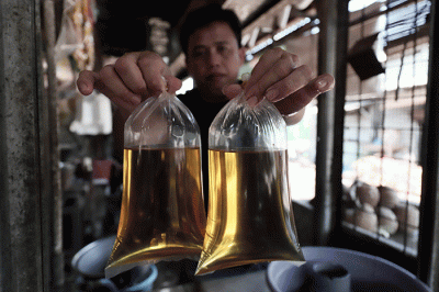 Pedagang menunjukkan minyak goreng curah disalah satu toko di kawasan Kota Bekasi, Jawa Barat, Senin (16/5/2022).