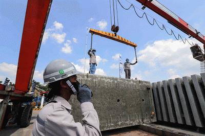 Pekerja membersikan slab track atau bantalan rel menggunakan terpal di Pabrik Slab Track PT Wika Beton, Karawang, Jawa Barat, Rabu (18/5/2022).