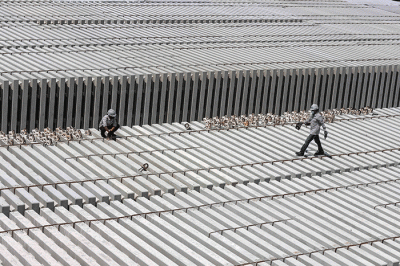Pekerja membersikan slab track atau bantalan rel menggunakan terpal di Pabrik Slab Track PT Wika Beton, Karawang, Jawa Barat, Rabu (18/5/2022).