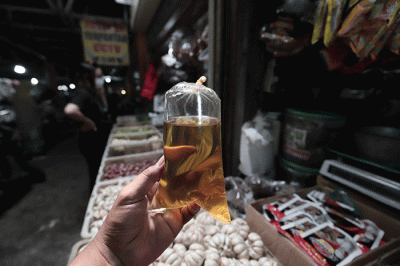 Pedagang mengemas minyak goreng curah di Pasar Kecapi, Kota Bekasi, Jawa Barat, Rabu (18/5/2022).
