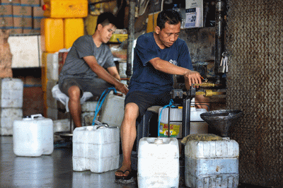 Penjual memasukkan minyak goreng curah ke dalam jerigen di Kawasan Pasar Cipete, Jakarta Selatan, Jumat (20/5/2022).