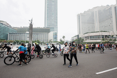 Sejumlah warga berolahraga di kawasan Bundaran HI, Jakarta Pusat, Minggu (22/5/2022).
