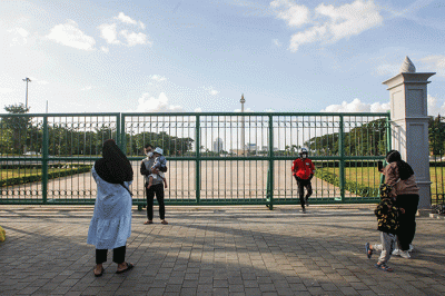 Sejumlah warga berfoto berlatar belakang Monumen Nasional (Monas) di Jakarta Pusat, Senin (23/5/2022).