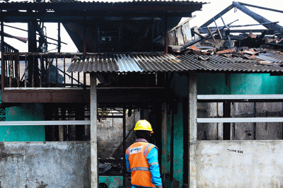Petugas pemadam kebakaran berusaha memadamkan api yang membakar rumah warga di Jalan Masjid Alhuda atau depan Stasiun Kebayoran Lama.