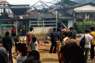 Petugas pemadam kebakaran berusaha memadamkan api yang membakar rumah warga di Jalan Masjid Alhuda atau depan Stasiun Kebayoran Lama.