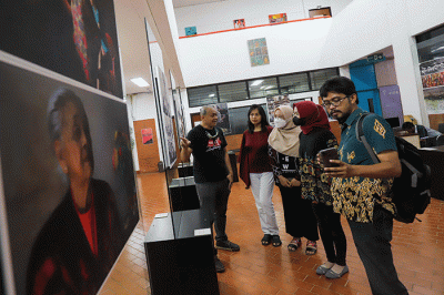 Pengunjung mengamati karya yang dipamerkan dalam pemeran foto bertajuk 