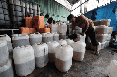 Pekerja menuangkan minyak goreng curah ke jerigen disalah satu agen kawasan Pondok Melati, Kota Bekasi, Jawa Barat, Rabu (25/5/2022).