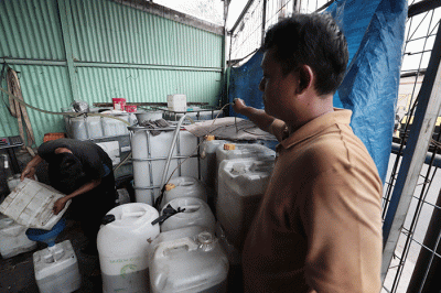 Pekerja menuangkan minyak goreng curah ke jerigen disalah satu agen kawasan Pondok Melati, Kota Bekasi, Jawa Barat, Rabu (25/5/2022).