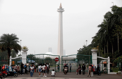 Warga berfoto dengan latar belakang Monumen Nasional di Jakarta, Kamis (26/5/2022).