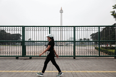 Warga berfoto dengan latar belakang Monumen Nasional di Jakarta, Kamis (26/5/2022).