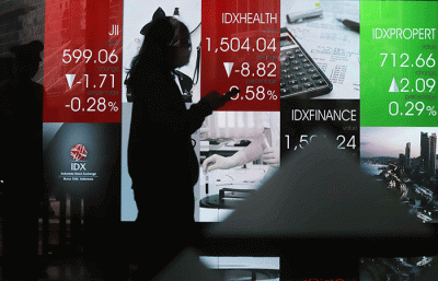 Pekerja melintasi layar pergerakan Indeks Harga Saham Gabungan (IHSG) di Bursa Efek Indonesia, Jakarta Selatan, Senin (30/5/2022).