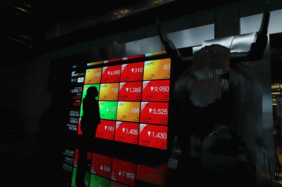 Pekerja melintasi layar pergerakan Indeks Harga Saham Gabungan (IHSG) di Bursa Efek Indonesia, Jakarta Selatan, Senin (30/5/2022).