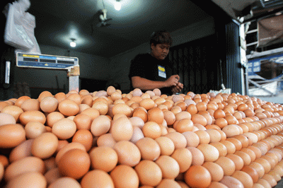 Pedagang telur ayam saat melayani pembeli di kawasan Kampung Makasar, Jakarta Timur, Minggu (29/5/2022).