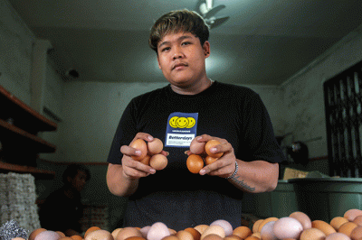Pedagang telur ayam saat melayani pembeli di kawasan Kampung Makasar, Jakarta Timur, Minggu (29/5/2022).