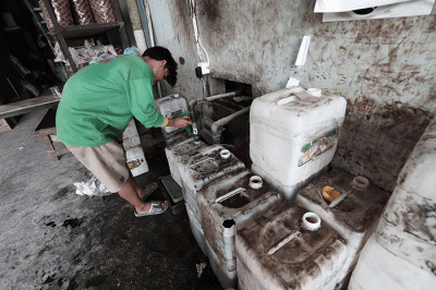 Pekerja menunjukkan minyak goreng curah di salah satu agen kawasan Pondok Melati, Kota Bekasi, Jawa Barat, Selasa (31/5/2022).