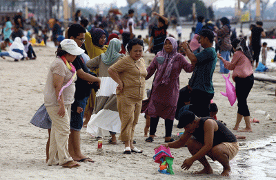 Warga berlibur di Pantai Ancol, Jakarta Utara, Rabu (1/6/2022).