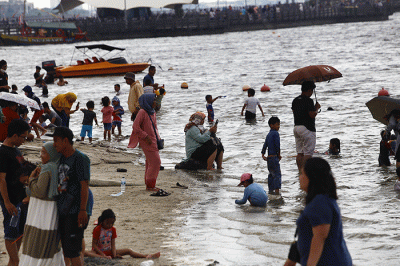Warga berlibur di Pantai Ancol, Jakarta Utara, Rabu (1/6/2022).