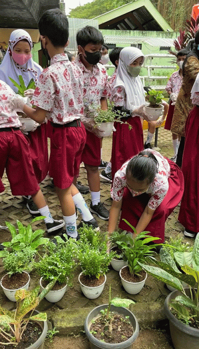 Direktur Capital Market MNC Sekuritas Afen (kiri) menyerahkan bantuan tanaman secara simbolis kepada Lurah Gondangdia Ichsan Kamil.