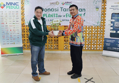 Direktur Capital Market MNC Sekuritas Afen (kiri) menyerahkan bantuan tanaman secara simbolis kepada Lurah Gondangdia Ichsan Kamil.