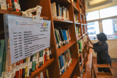 Pengunjung membaca buku di perpustakaan 