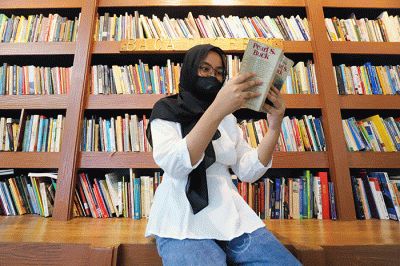 Pengunjung membaca buku di perpustakaan 