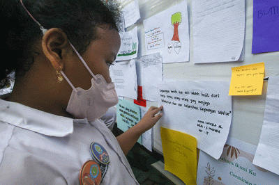 Sejumlah siswa menempelkan tulisan sebuah harapan untuk ekosistem lingkungan pada mading sekolah di kompleks SD Negeri Pekunden Semarang, Jawa Tengah.