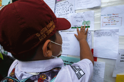 Sejumlah siswa menempelkan tulisan sebuah harapan untuk ekosistem lingkungan pada mading sekolah di kompleks SD Negeri Pekunden Semarang, Jawa Tengah.
