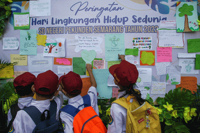 Sejumlah siswa menempelkan tulisan sebuah harapan untuk ekosistem lingkungan pada mading sekolah di kompleks SD Negeri Pekunden Semarang, Jawa Tengah.