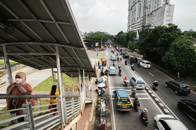 Aktivitas warga saat pulang kerja di Jembatan Penyeberangan Orang (JPO) Tanjung Barat, Jakarta Selatan, Selasa (7/6/2022).