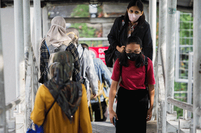 Aktivitas warga saat pulang kerja di Jembatan Penyeberangan Orang (JPO) Tanjung Barat, Jakarta Selatan, Selasa (7/6/2022).