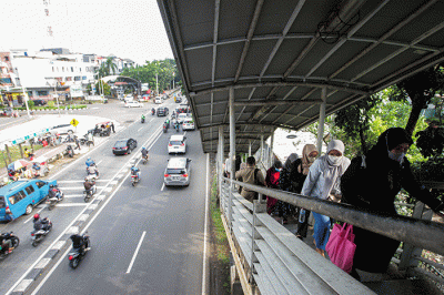 Aktivitas warga saat pulang kerja di Jembatan Penyeberangan Orang (JPO) Tanjung Barat, Jakarta Selatan, Selasa (7/6/2022).