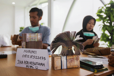 Petugas saat melayani penukaran mata uang Saudi Riyal untuk jamaah haji di Asrama Haji Pondok Gede, Jakarta Timur, Rabu (8/6/2022).