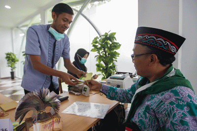 Petugas saat melayani penukaran mata uang Saudi Riyal untuk jamaah haji di Asrama Haji Pondok Gede, Jakarta Timur, Rabu (8/6/2022).