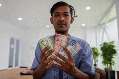 Petugas saat melayani penukaran mata uang Saudi Riyal untuk jamaah haji di Asrama Haji Pondok Gede, Jakarta Timur, Rabu (8/6/2022).