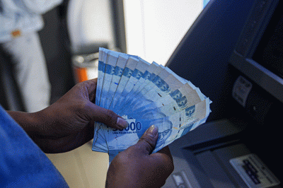 Seorang warga menunjukkan uang sebelum melakukan setor tunai di salah satu Anjungan Tunai Mandiri (ATM) kawasan Jakarta Timur, Kamis, (9/6/2022).