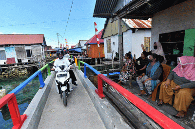Presiden Joko Widodo dan Ibu Iriana Joko Widodo menaiki sepeda motor listrik saat kunjungan kerjanya di Kabupaten Wakatobi, Sulawesi Tenggara.