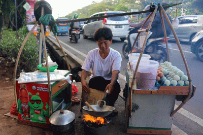 Pedagang membuat kerak telor di kawasan Jalan Benyamin Sueb, Jakarta, Sabtu (11/6/2022).
