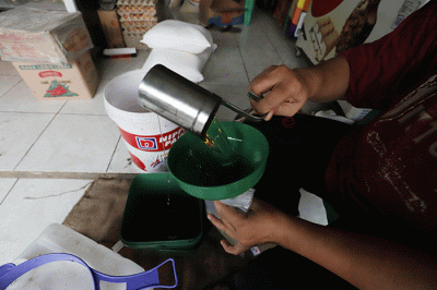Pedagang mengemas minyak goreng curah di salah satu toko kawasan Kota Bekasi, Jawa Barat, Sabtu (11/6/2022).