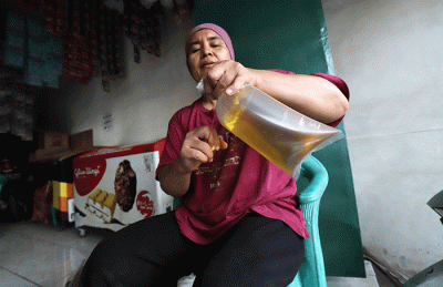 Pedagang mengemas minyak goreng curah di salah satu toko kawasan Kota Bekasi, Jawa Barat, Sabtu (11/6/2022).