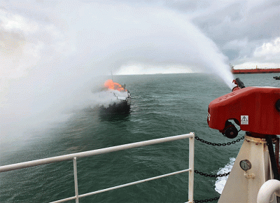 KN Pulau Dana-323 Bakamla RI melaksanakan pemadaman KM Bintang Surya yang terbakar di Perairan Karimun, Selat Malaka, Riau, Minggu (12/6/2022).
