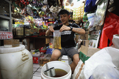 Pedagang menunjukkan minyak goreng curah di Pasar Kebayoran Lama, Jakarta, Senin (13/6/2022).