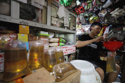 Pedagang menunjukkan minyak goreng curah di Pasar Kebayoran Lama, Jakarta, Senin (13/6/2022).