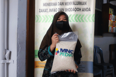 Head of CSR MNC Group Tengku Havid saat menyerahkan bantuan paket beras secara simbolik kepada Nurhasanah yang merupakan perwakilan Panti Asuhan Nurul Hasanah.