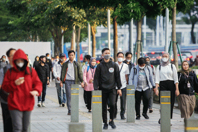 Sejumlah pekerja melintasi pedestrian di kawasan Dukuh Atas, Jakarta Pusat, Senin (20/6/2022).