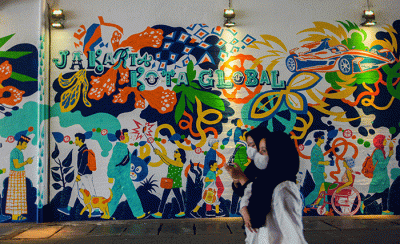 Sejumlah warga berjalan melintasi mural di Terowongan Kendal, Sudirman, Jakarta, Rabu (29/6/2022).